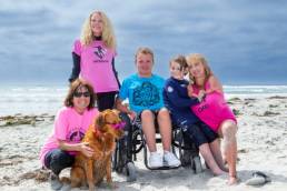 Ricochet the Surf Dog with his family on the breach