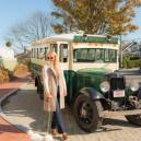 Woman standing in front of an old vintage Ford bus with her small dog at the Nantucket Hotel