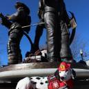 Molly the Fire Safety Dog under firefighter statue